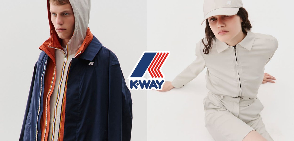 Joven vestido con chaquetas con capucha en capas, de pie junto a una joven sentada con un conjunto claro con cremallera y gorra, sobre un fondo blanco.