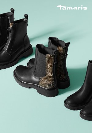 Zwarte enkellaarzen met een chunky zool, voorzien van een textuuraccent in slangenprint aan de zijkant en elastische panels voor eenvoudig aan- en uittrekken.