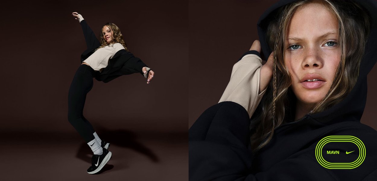 Woman wearing black and beige activewear and Nike sneakers leans backward with arms extended against a dark brown background.