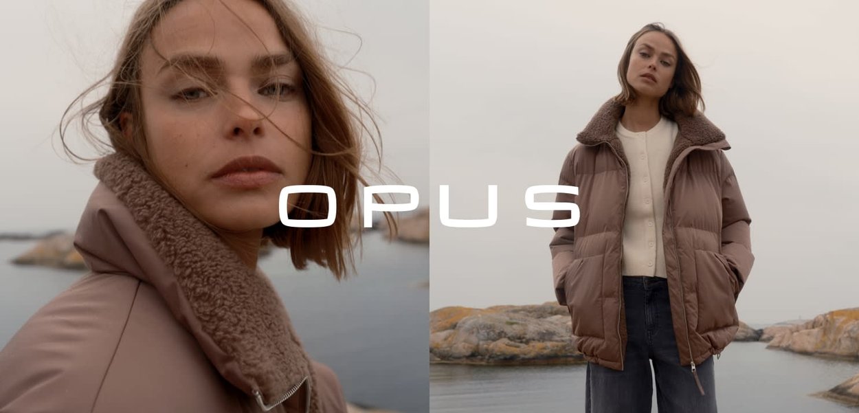 Giubbotto imbottito marrone con colletto in shearling, dotato di chiusura con zip e tasche laterali, indossato sopra un maglione leggero e jeans.