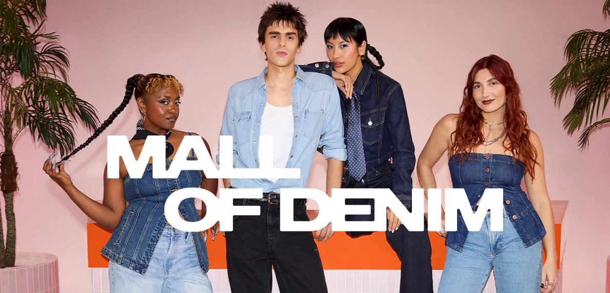 Vier individuen poseren in denimoutfits. Belangrijke kenmerken zijn de blauwe kleuren, verschillende texturen en stijlen. Een roze achtergrond verfraait de scène.