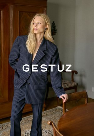 Navyblaues Streifenanzug mit maßgeschneidertem Blazer und passender Hose. Verfügt über einen Ein-Knopf-Verschluss und eine Seitentasche. Glatter Stoff mit angenehmer Textur.