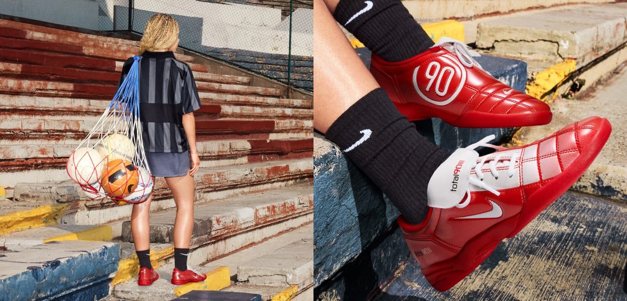 Persona con botas de fútbol rojas lleva una bolsa de red con balones de fútbol por las escalas desgastadas de un estadio; primer plano muestra botas rojas brillantes con el número 90.