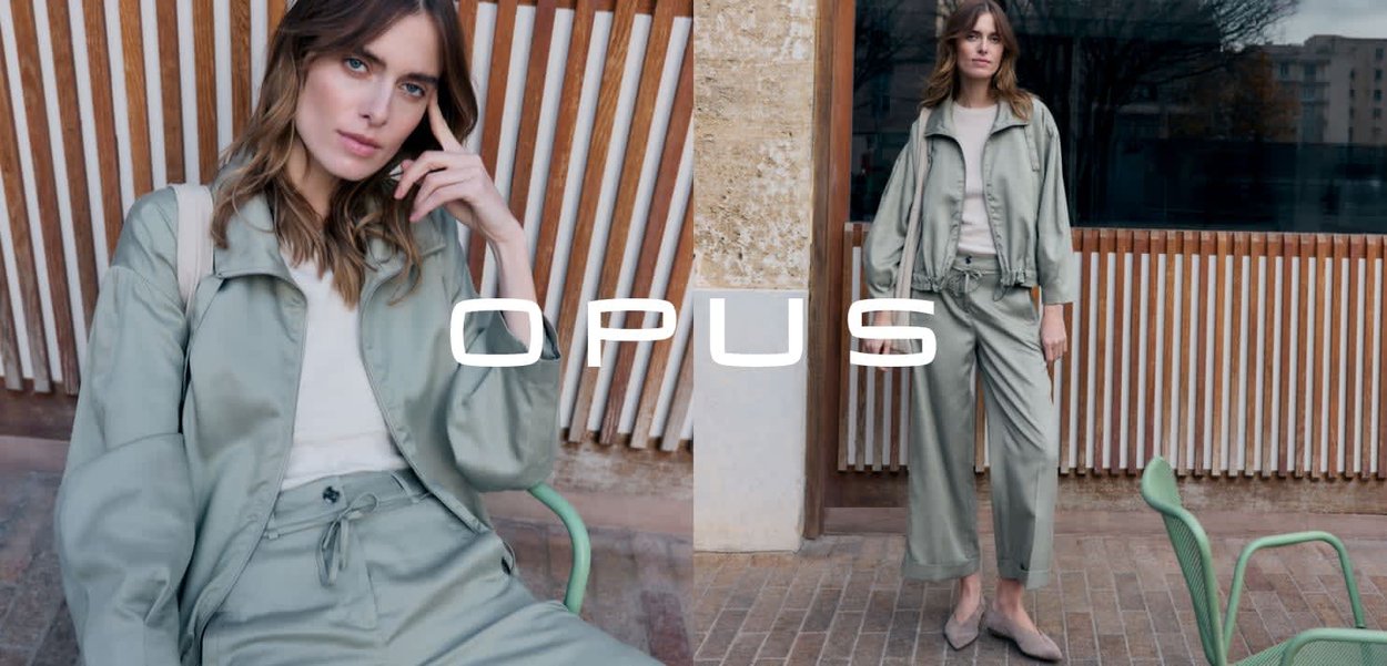 Frau in hellgrüner Jacke und Hose posiert sitzend und stehend vor einem Hintergrund aus Holzlatten und einer Backsteinmauer im Freien.