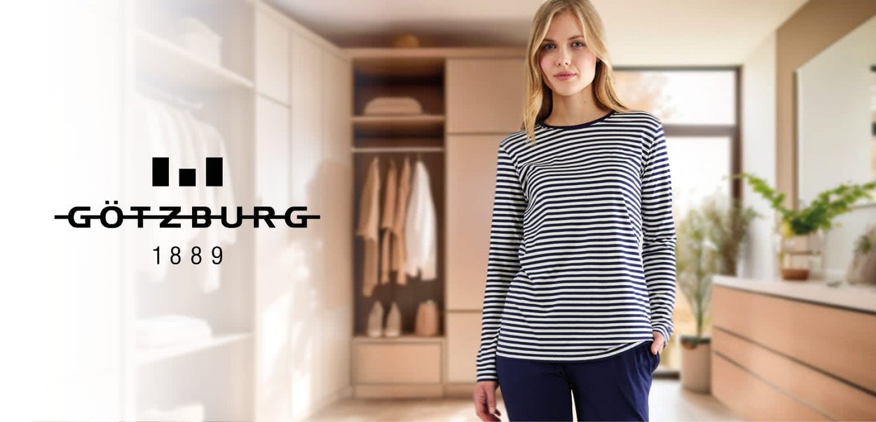 Long-sleeve, navy and white striped top in a soft fabric, paired with dark pants, set against a light, modern interior with organized storage.