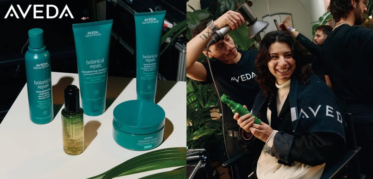Aveda botaniske reparationshårprodukter i blågrønne flasker, herunder shampoo, balsam og stylingcreme, med en grøn behandling i hånden.