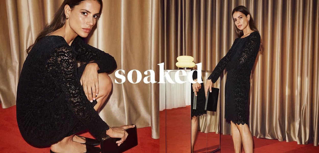 Schwarzes Spitzenkleid mit langen Ärmeln und gewelltem Saum. Modell posiert sitzend und stehend, mit einem Lächeln. Schwarze Clutch und Hintergrund.