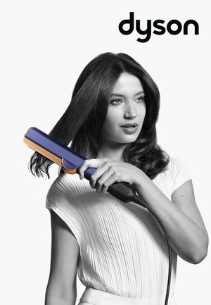 Piastra per capelli Dyson blu con accentuazioni arancioni, dotata di un cilindro rotondo, impugnatura texturizzata e un lungo cavo di alimentazione.