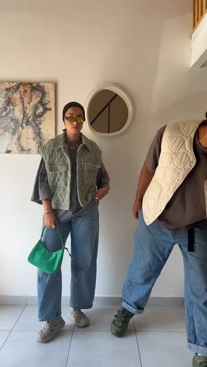 Zaļa, plecu džaka jaka uz pelēka krekla, apvienota ar pārāk lielām zilo džinsiem. Aksesuāros iekļauts zaļš rokassomiņas un dzelteni saulesbrilles. Balta apļa spogulis fonā.