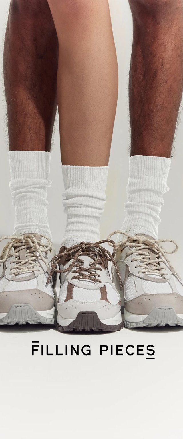 Las zapatillas Filling Pieces presentan un diseño de materiales mixtos en beige, blanco y marrón, con suelas texturizadas y formas redondeadas. Se llevan calcetines blancos de canalé.