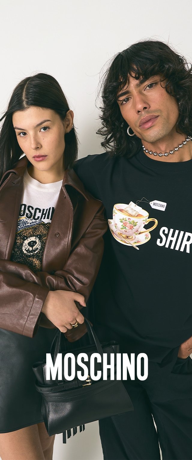 Schwarzes T-Shirt mit einer Teetasse-Grafik und dem Text "MOSCHINO", kombiniert mit einem weißen Hemd, das einen Bären zeigt. Die Models halten eine kleine schwarze Handtasche.