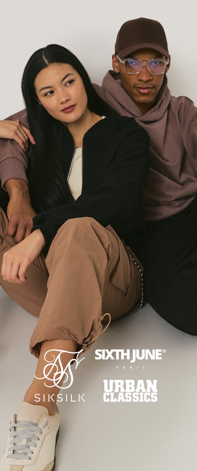 Veste noire zippée, haut beige, pantalon cargo marron et baskets blanches. Sweat à capuche marron clair avec une casquette assortie ; lunettes sur la droite.
