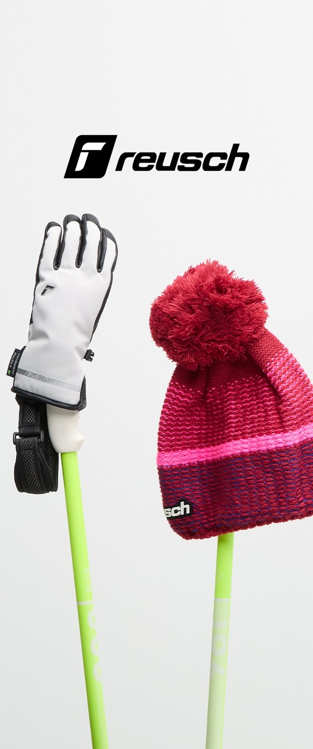 Gant de ski blanc avec des accents noirs et cinq doigts, accompagné d'un bonnet tricoté rouge avec un pompon et une bande rose. Des bâtons verts à l'arrière-plan.