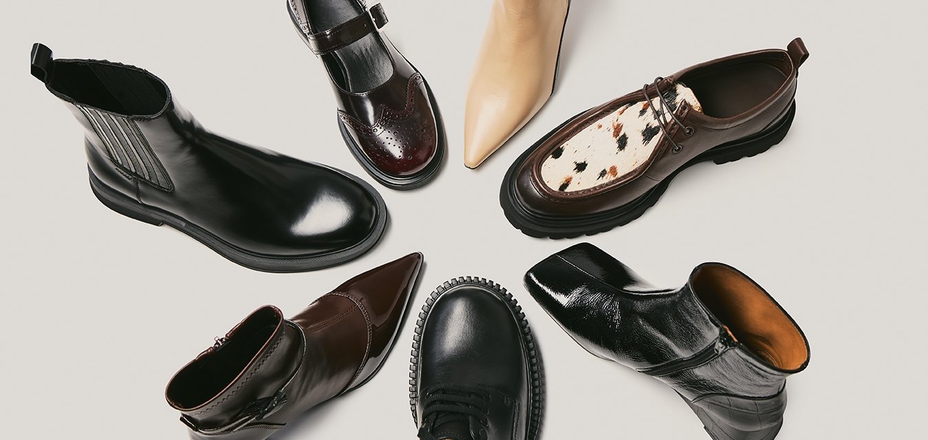 Sedm párů bot různých stylů: kožené kotníkové boty v černé a hnědé barvě, béžová špičatá bota a hnědá bota s tečkovaným detaily.