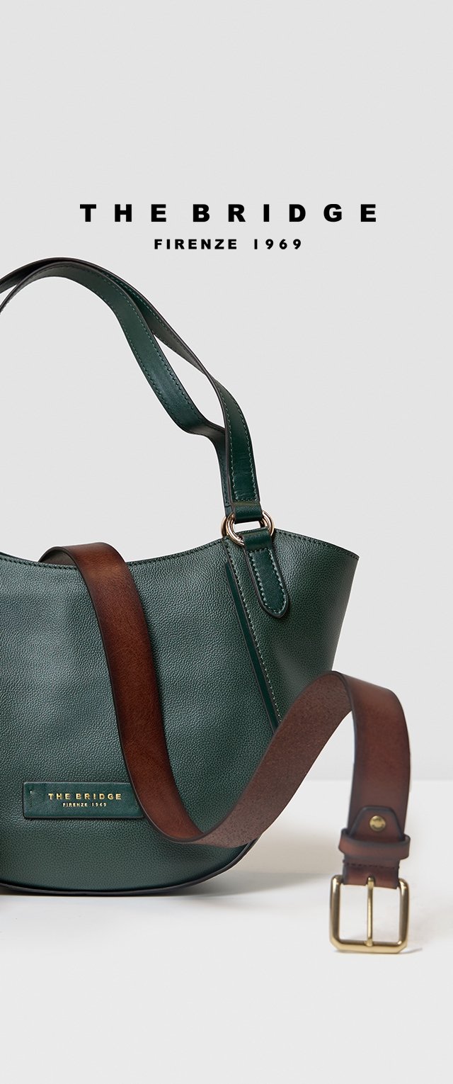Bolso de mano de cuero verde con un acabado texturizado, una correa de hombro marrón y detalles en hardware dorado. Presenta una placa con el nombre de la marca en relieve.