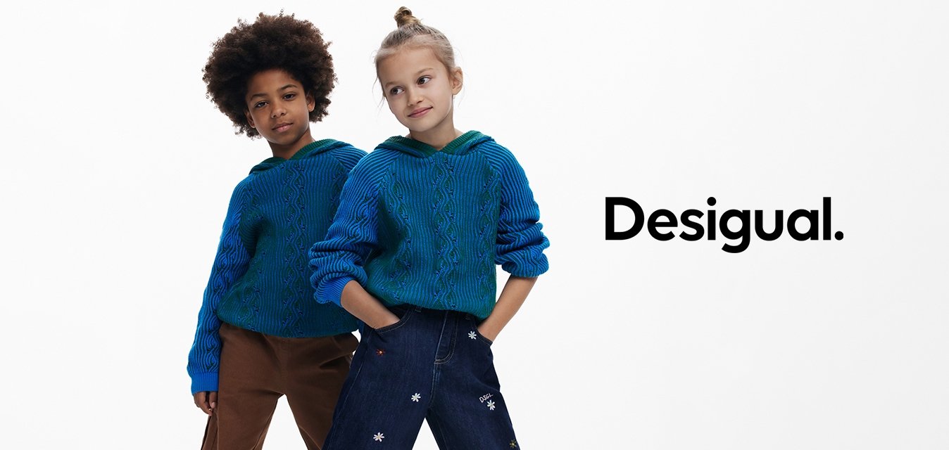 Modré pletené mikiny s kapucí a ribbovanou strukturou, spárované s volnými tmavými džínami se květinovou výšivkou. Béžové slip-on boty.