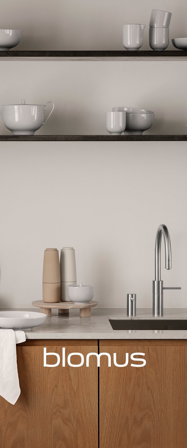 Minimalistisk köksscen med träskåp, en grå bänkskiva och vit keramikservis på metallhyllor. Anmärkningsbar blandad stålkran.