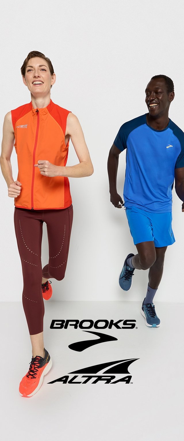 Twee hardlopers in sportkleding. De één draagt een oranje vest en bordeauxrode leggings; de ander heeft een blauwe shirt en shorts aan. Beide hebben kleurrijke hardloopschoenen.