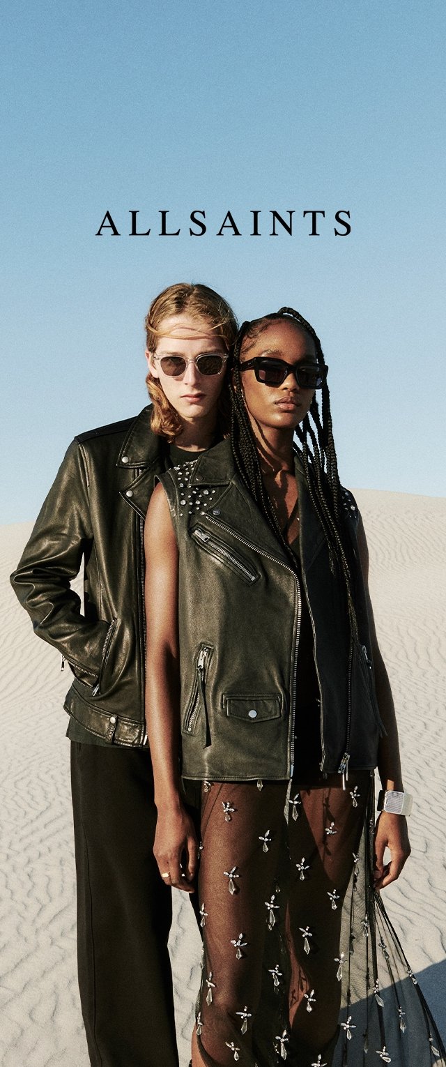 Deux mannequins portent des vestes en cuir noires, l'une avec des clous en argent. L'autre porte une robe transparente brodée par-dessus un pantalon sombre. Des lunettes de soleil complètent le look.