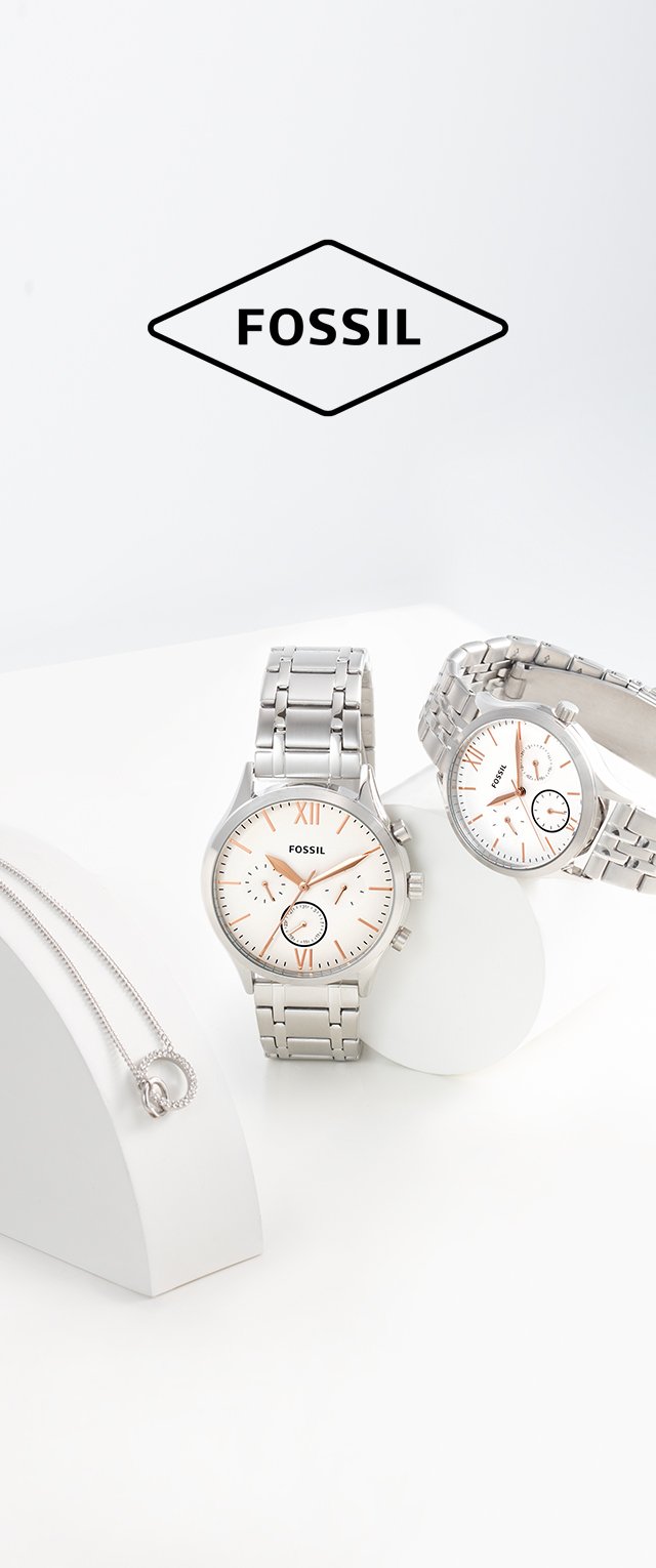 Orologi in acciaio inossidabile argento con quadranti bianchi, dettagli in oro rosa e indicatori numerici esposti su supporti bianchi, insieme a una collana a pendente argento.