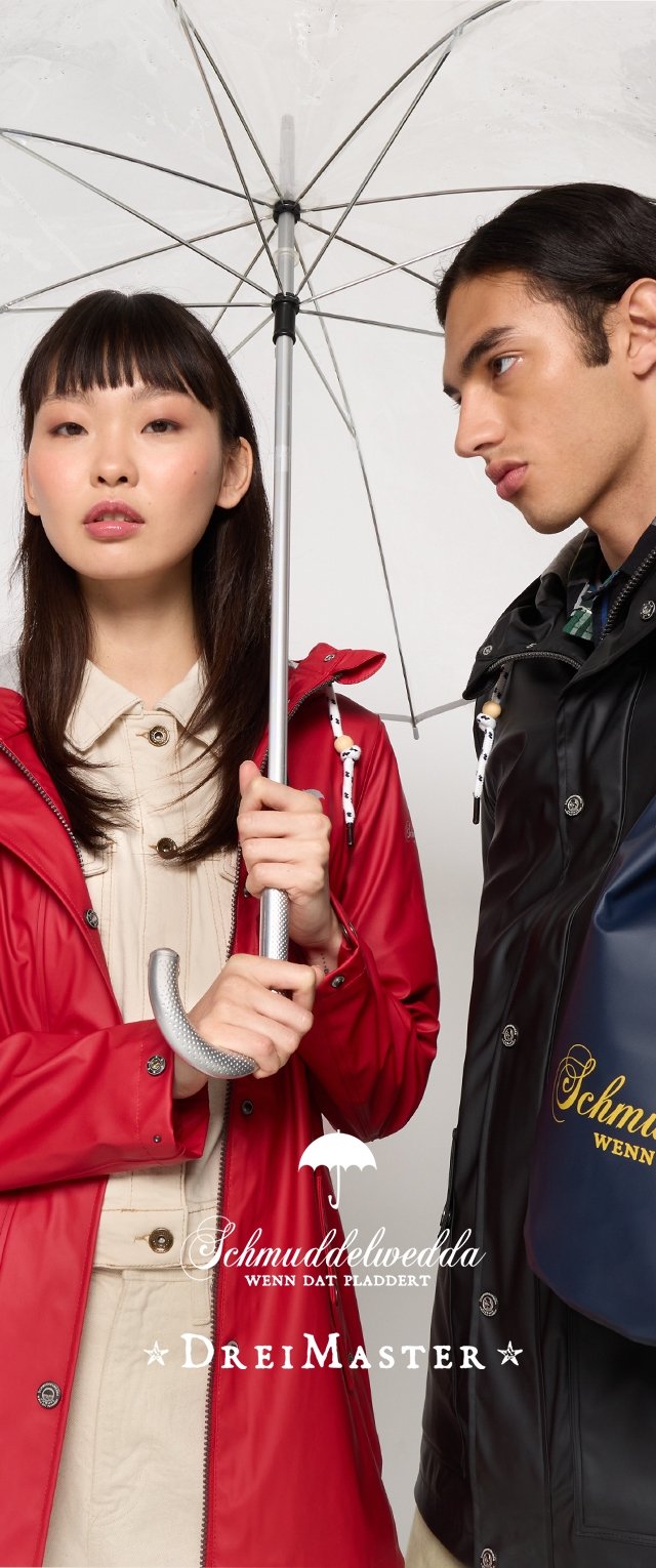 Rote wasserdichte Jacke mit Knöpfen, darunter ein hellbeiges Hemd, transparenter Regenschirm, schwarze wasserdichte Jacke mit Logo und blaue Tasche.