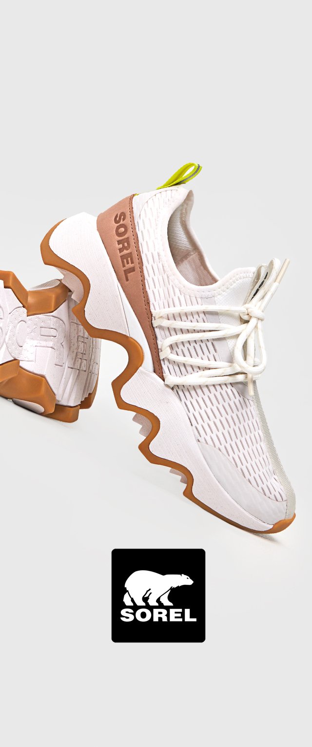 Białe siatkowe sneakersy z brązowym akcentem i żółtą pętelką do zakupu. Posiadają nieregularną, teksturowaną podeszwę dla lepszej przyczepności oraz ciekawego designu. Wyświetlone logo Sorel.