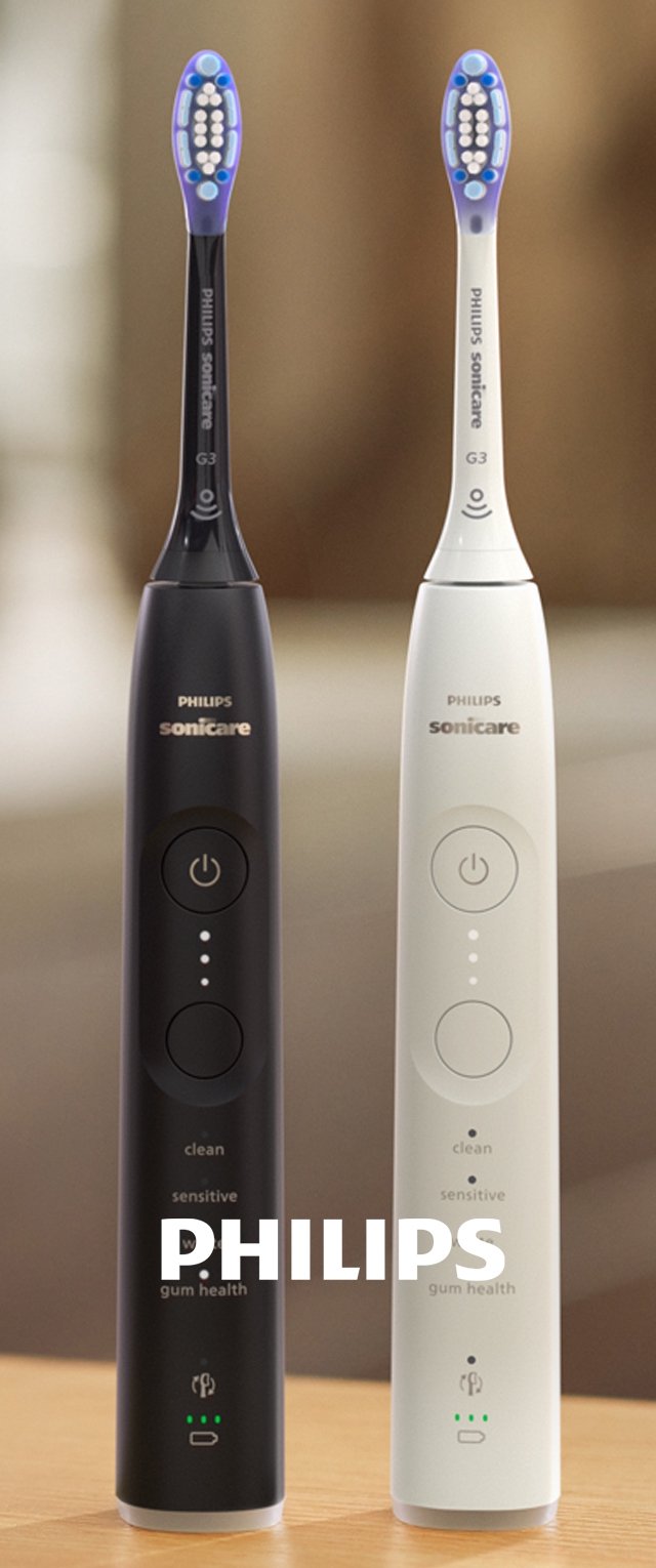 Dos cepillos de dientes eléctricos Philips Sonicare G3, uno negro y otro blanco, colocados en posición vertical sobre una superficie de madera con los botones de modo y encendido visibles.