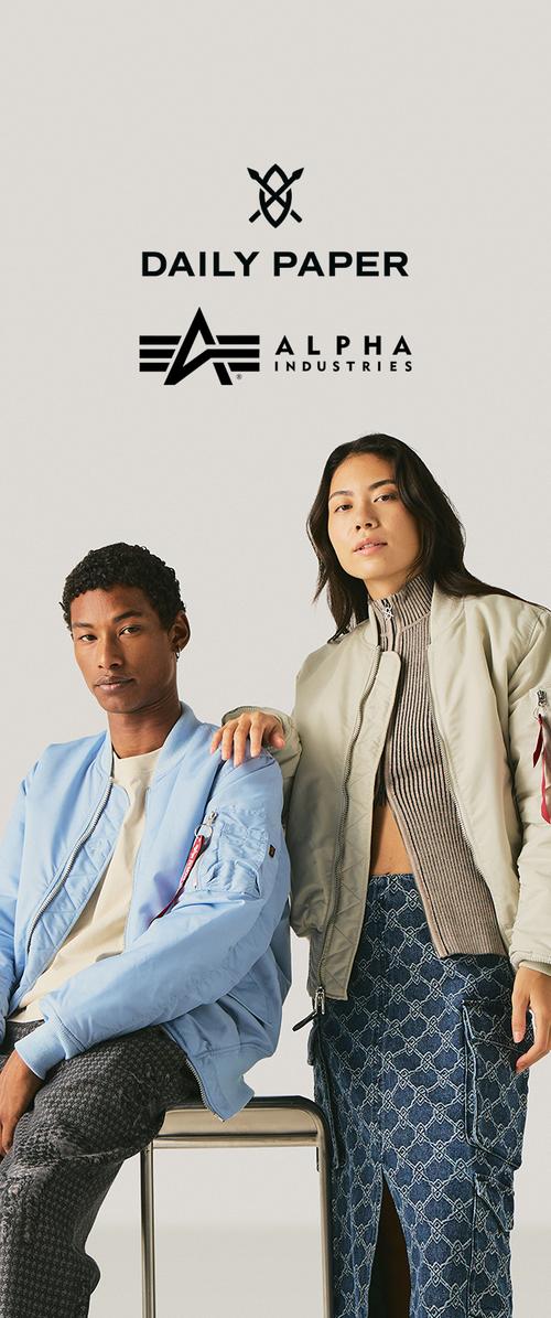 Dwoje młodych modeli w casualowych kurtkach pozują pod logo Daily Paper i Alpha Industries na jednolitym jasnym tle.