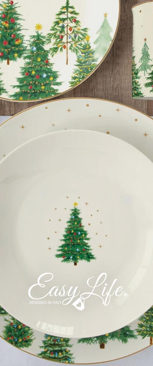 Juego de platos blancos y una taza decorados con árboles de Navidad coloridos y pequeñas estrellas doradas sobre una superficie de madera.