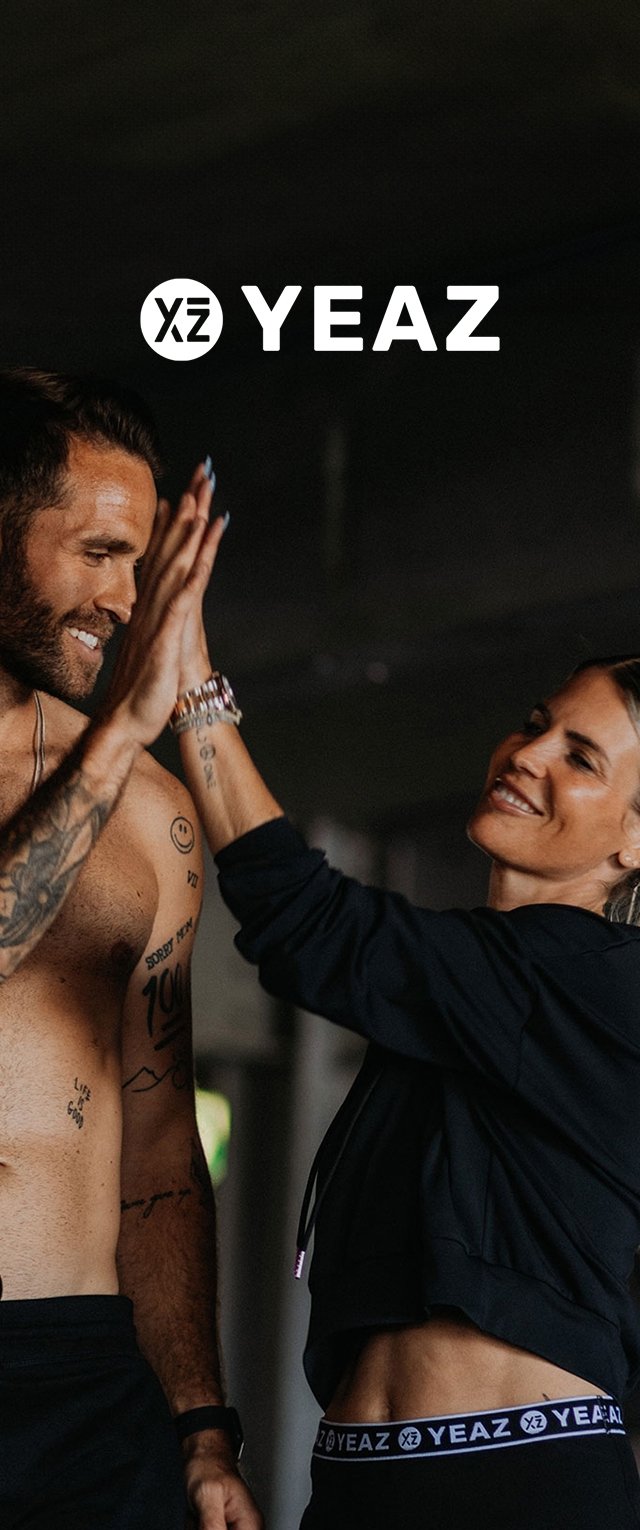 Due persone si stanno dando un cinque in un ambiente urbano poco illuminato. Uno indossa un cropped black hoodie, mentre l'altro è a torso nudo con tatuaggi visibili.