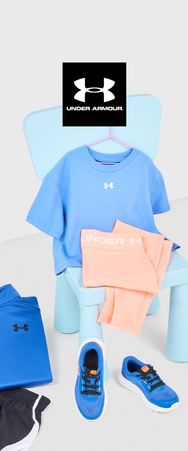 T-shirt en coton bleu avec logo, leggings pêche, baskets bleues avec semelles blanches, et shorts noirs posés sur une chaise bleu clair.