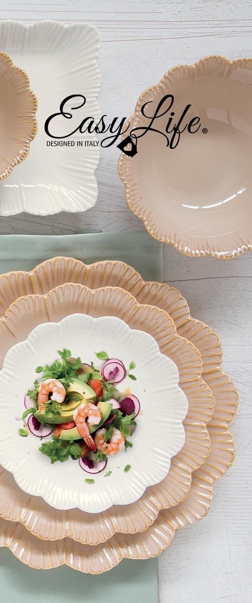 Platos de cerámica con borde ondulado, variados en beige y blanco, uno con ensalada de camarones, aguacate, rábano y lechuga sobre una superficie de madera clara.
