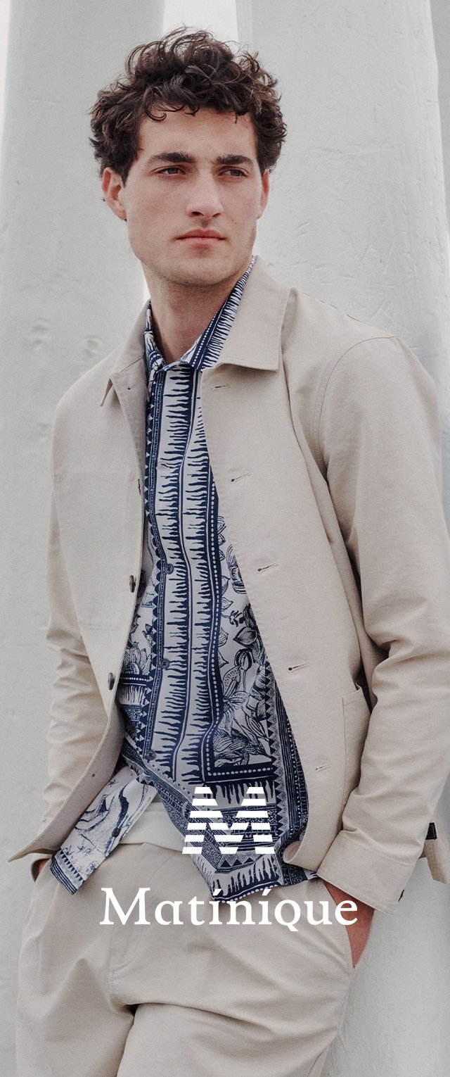Hellbebige Jacke über einem blau-weißen gemusterten Hemd mit filigranen Designs. Das Model steht vor einem hellen Hintergrund. Marke: Matinique.