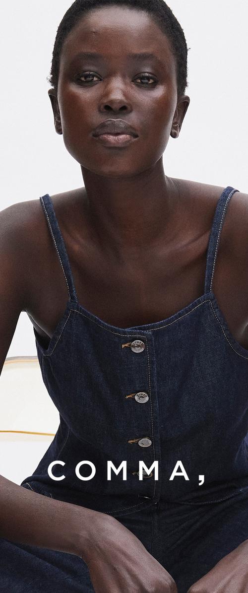 Mujer con el pelo corto que lleva una blusa sin mangas de mezclilla oscura con botones sobre un fondo blanco con el texto "COMMA".