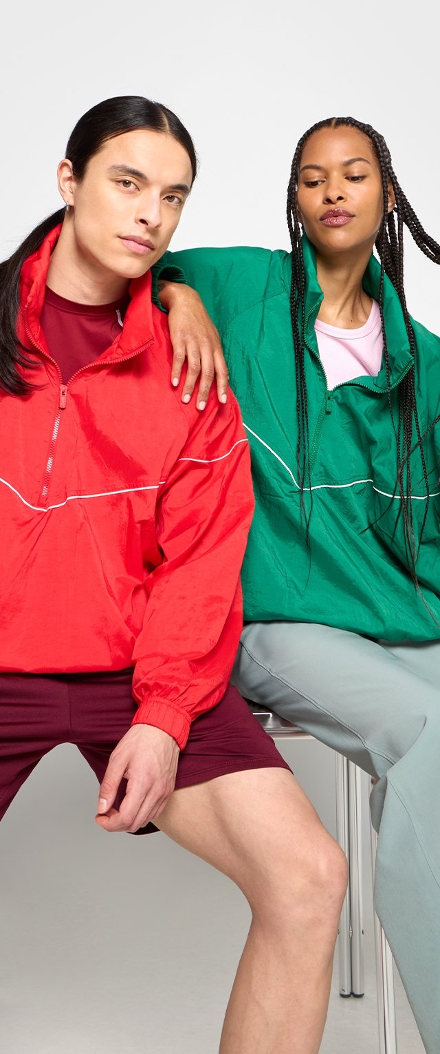 Czerwone i zielone kurtki przeciwwiatrowe z białymi akcentami, w połączeniu z bordowymi szortami i jasnoszarymi spodniami. Gładka tekstura, zamek błyskawiczny.