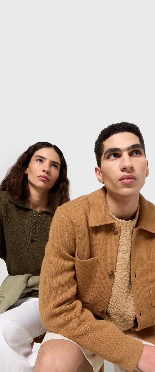 Deux mannequins posent vêtus de manteaux texturés ; l'un en vert olive, l'autre en beige. Les deux vêtements présentent des détails avec des boutons et des poches.