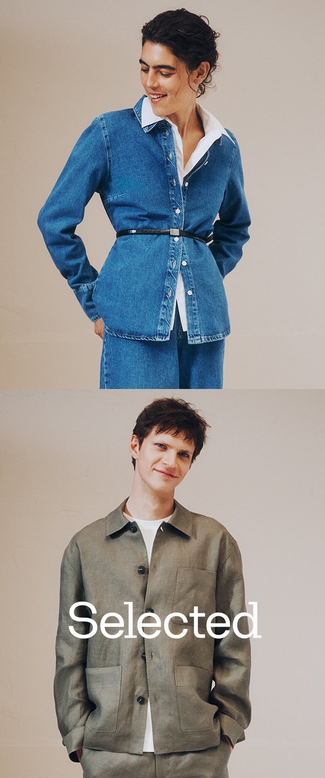 Kvinde iført denimjakke med bælte og hvid skjorte, mand i olivengrøn knappet jakke og bukser, begge smilende mod en ensfarvet baggrund.