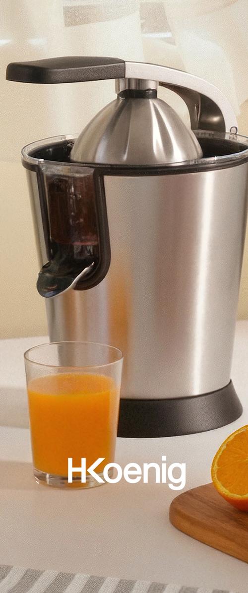 Elektrische Zitronenpresse aus Edelstahl mit schwarzem Griff, Glas Orangensaft und eine halbe Orange auf einem Holzbrett.