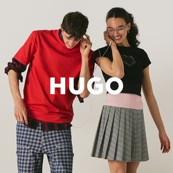 Teenager chlapec a dívka sdílejí sluchátka, stojí blízko u sebe, usmívají se; on má na sobě červenou košili a kostkované kalhoty, ona má černý top a šedou sukni.