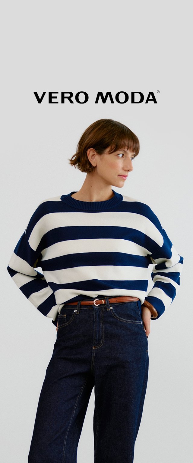 Sweter w granatowo-białe paski z okrągłym dekoltem, luźny krój i ściągacze przy mankietach, zestawiony z ciemnoniebieskimi jeansami o wysokim stanie.