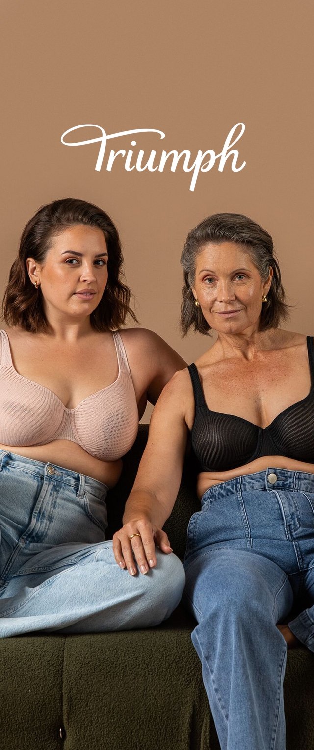 Dos mujeres sentadas en un sofá verde, usando sujetadores: una de color rosa claro con un diseño texturizado, y la otra de color negro con un patrón de rayas.