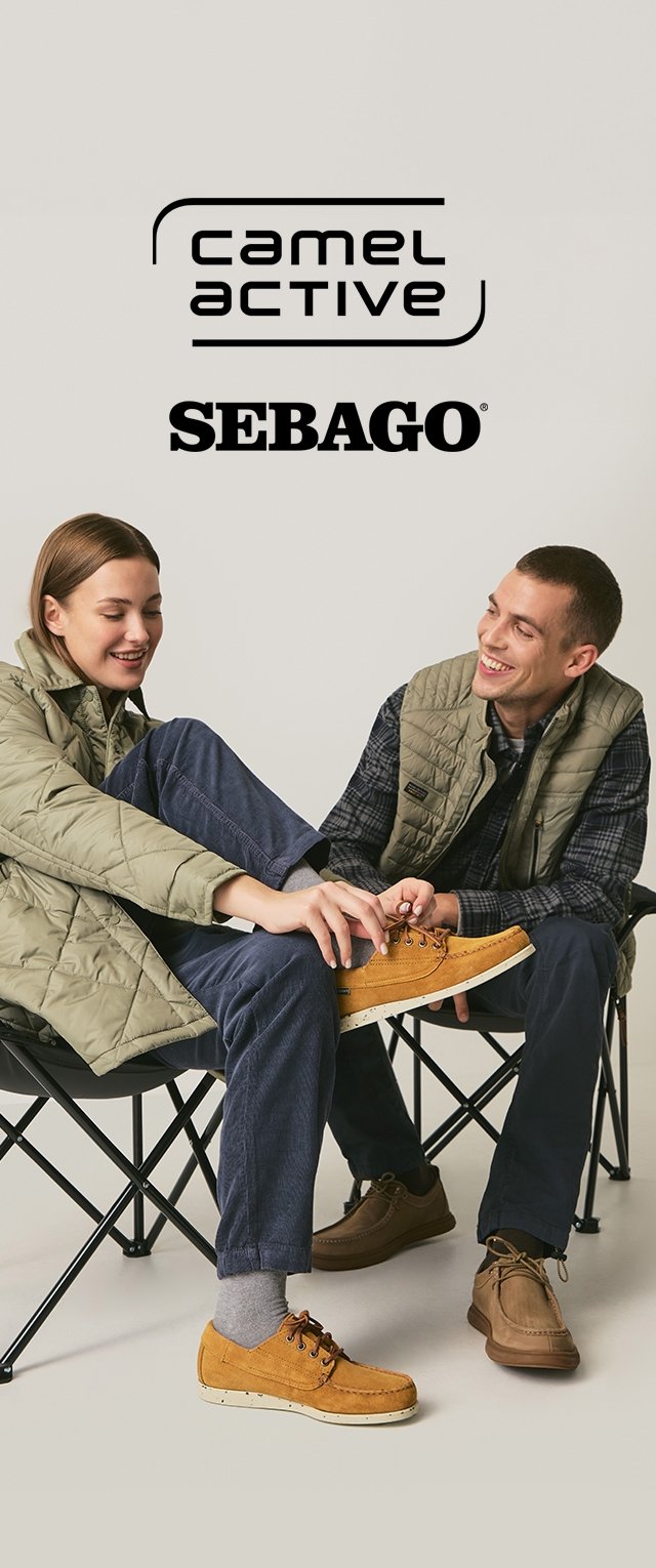 Dos personas están sentadas en sillas plegables vistiendo chalecos acolchados. Una lleva pantalones azul marino y zapatos amarillos; la otra lleva zapatos marrones y pantalones grises.