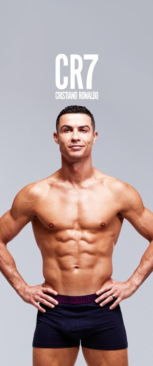 Crne bokserice s ljubičastim pojasom na kojem je natpis "CR7" i "Cristiano Ronaldo". Model je bez majice, pokazuje mišićavu tjelesnu građu.