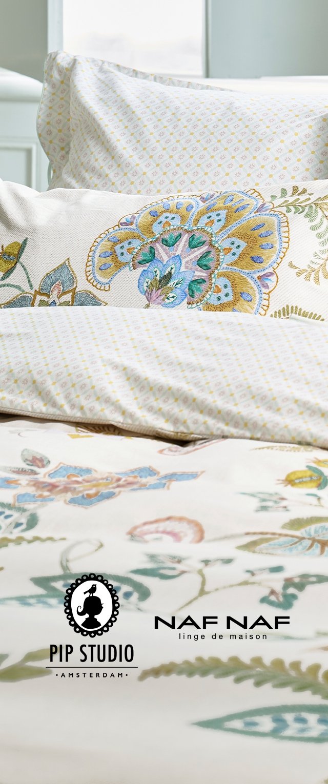 Ropa de cama blanca con bordados florales en tonos azules, verdes y amarillos, con fundas de almohada pequeñas estampadas y logotipos de Pip Studio y Naf Naf.