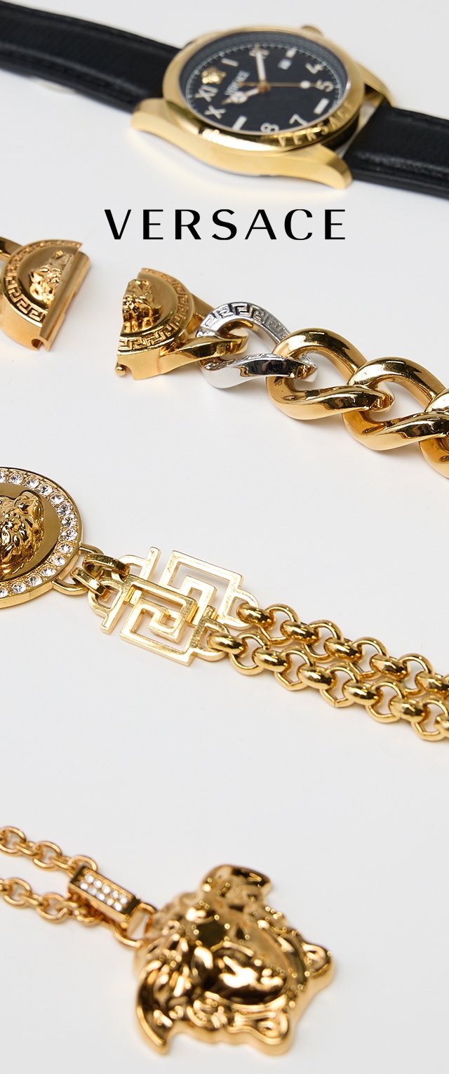Goldschmuckauswahl mit einer schwarzen Armbanduhr, einer Gliederarmband, Löwenkopfhängern und dekorativen Akzenten mit geometrischen Mustern.