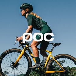 Cyklista v černém oblečení jede na žlutém kole do kopce po prašné cestě, na pozadí je jasná modrá obloha a zeleň.
