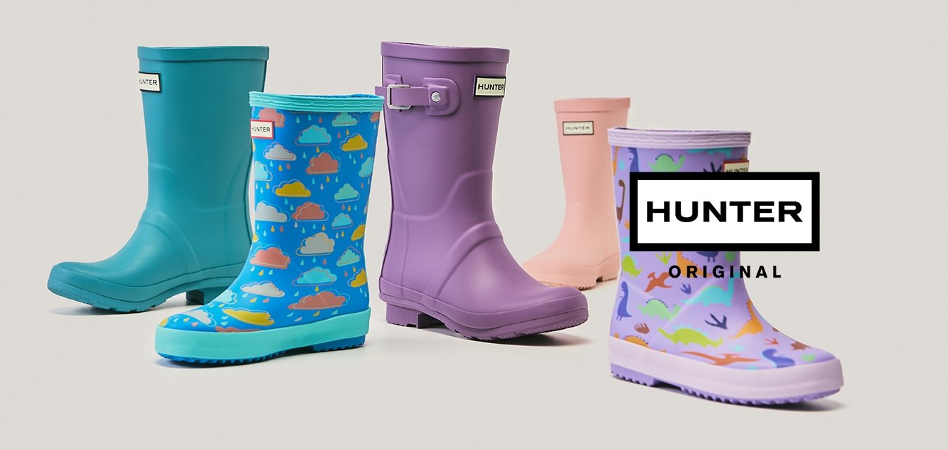 Pět barevných gumáků v modré, fialové, růžové a vzorované barvě uspořádaných do nestejné řady na jednobarevném pozadí.