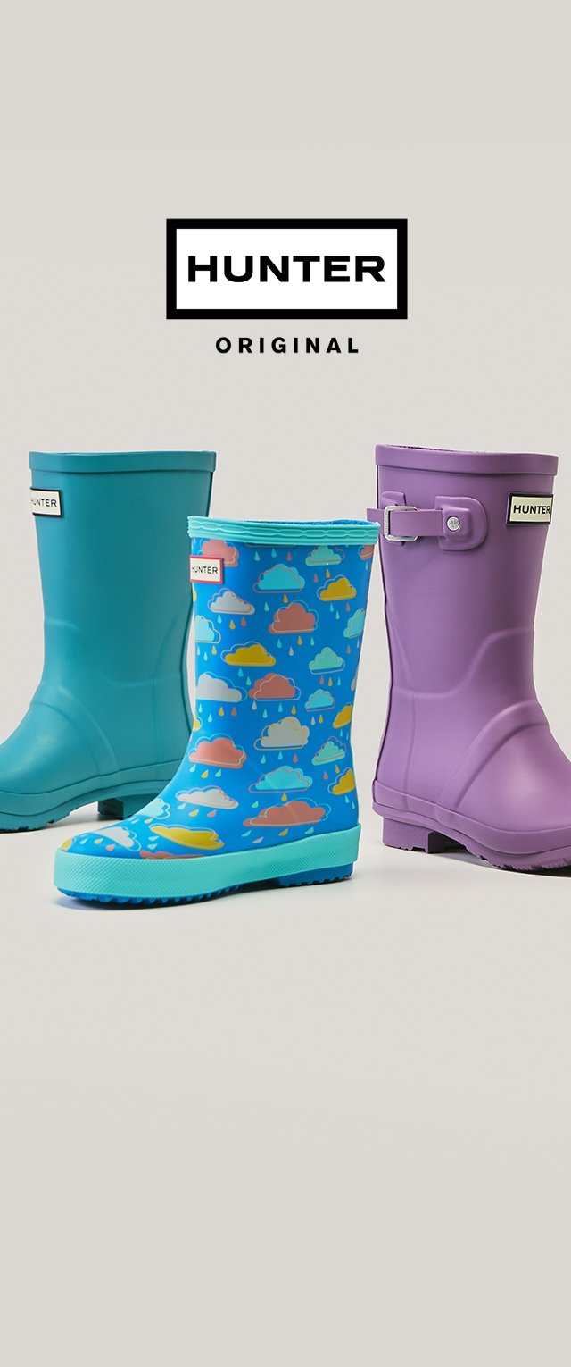 Trois paires de bottes de pluie Hunter : bleu sarcelle, bleu avec motif nuage, et violet. En caoutchouc, avec semelles texturées et détails de marque.