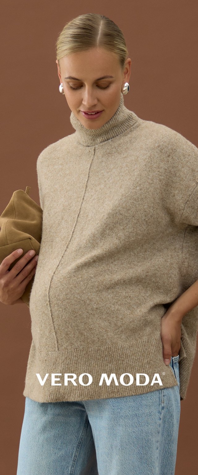 Beżowy sweter z golfem wykonany na drutach, o luźnym kroju, z centralnym szwem, noszony z jasnobłękitnymi dżinsami i trzymany w ręku brązowy kopertówka.