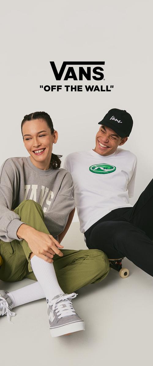 Gray sweatshirt with "VANS" text, green logo T-shirt, green pants, gray sneakers; casual style, relaxed fit, and white socks.